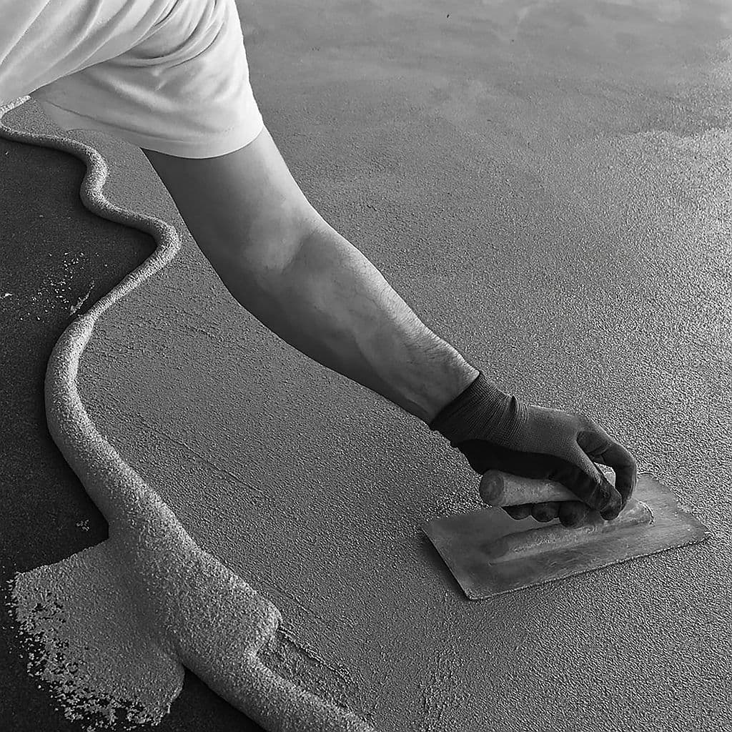 Colortale artisan hand-trowelling a seamless decorative floor finish