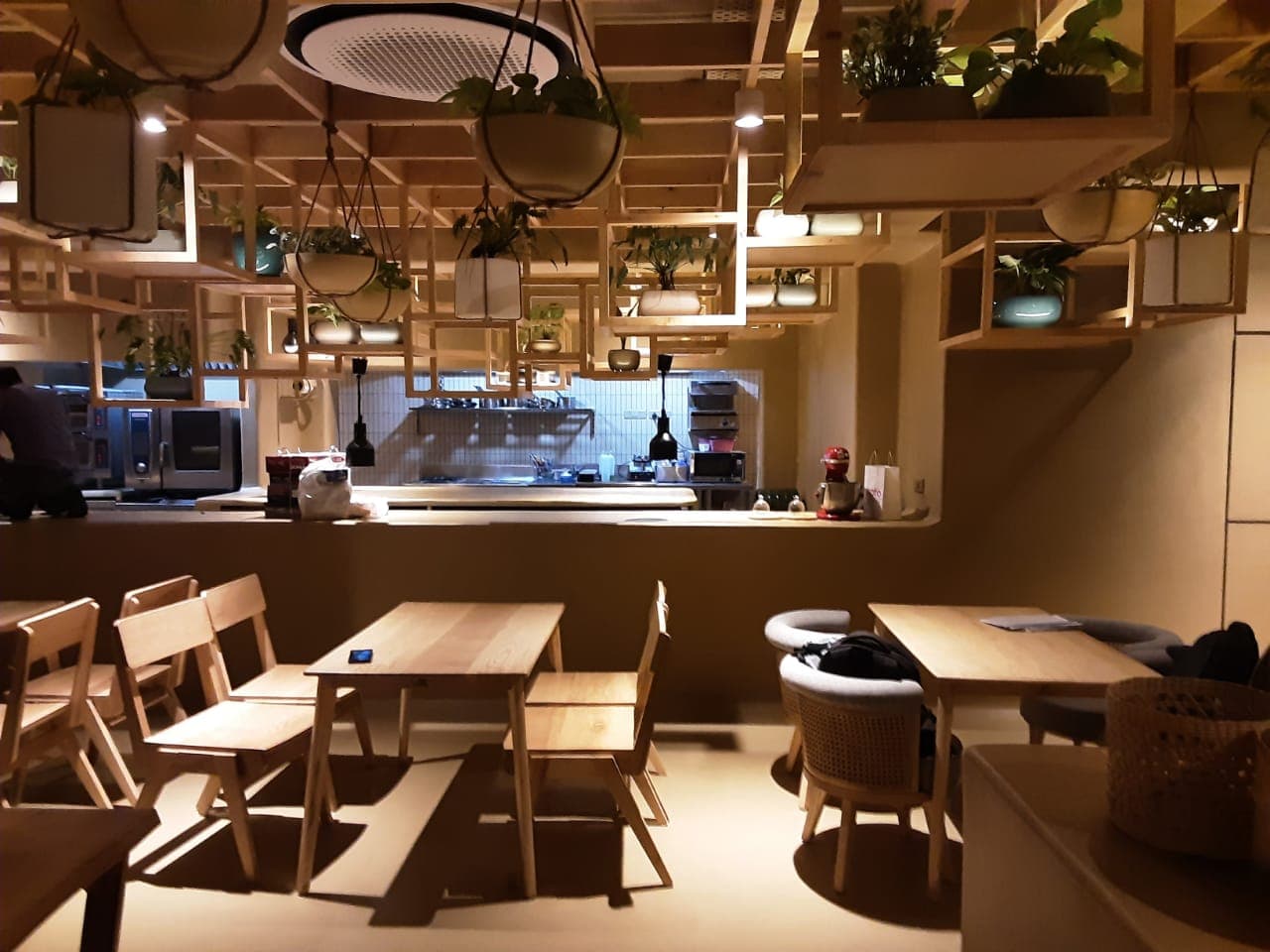 OMO Cafe interior with seamless warm beige tadelakt on the floor and counter, wood furniture and a planted wooden ceiling grid OMO Cafe interior with seamless warm beige tadelakt on the floor and counter, wood furniture and a planted wooden ceiling grid